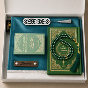 Le coffret tapis de prière personnalisé bleu Turquoise Sajadah avec son tapis à franges blanches, sa lanière en cuir véritable couleur chocolat, son tasbih effet classique, son exemplaire de "la citadelle du musulman" vert et son exemplaire du "Saint Coran" vert.