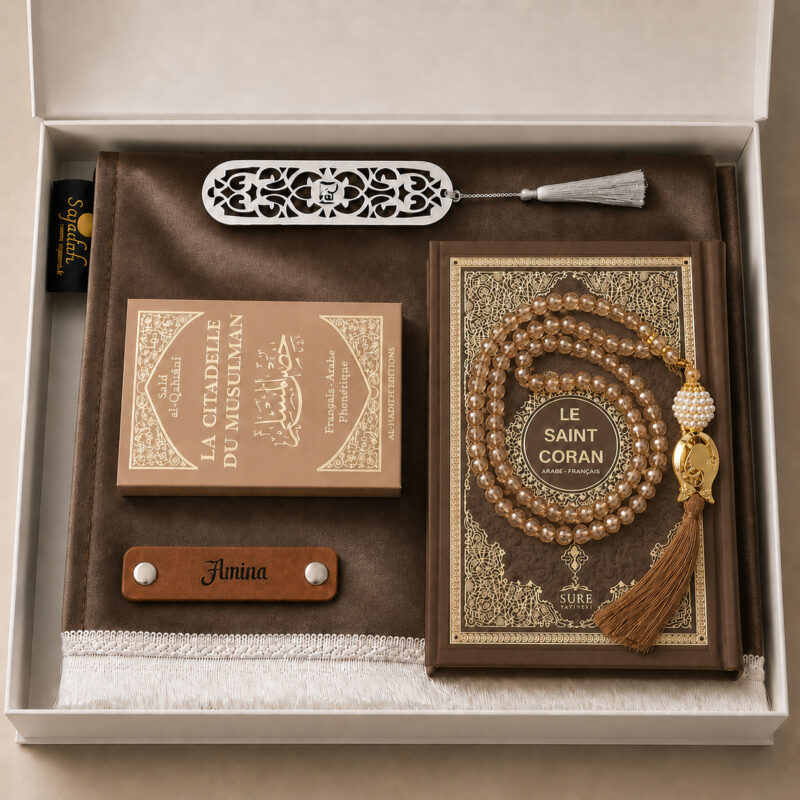 Das personalisierte Sajadah Gebetsteppich-Geschenkset in Zimtbraun mit einem Teppich mit weißen Fransen, einem Riemen aus echtem braunem Leder, einem Tasbih in Kristalloptik, einem Exemplar von „Die Festung des Muslims“ und einem Koran.