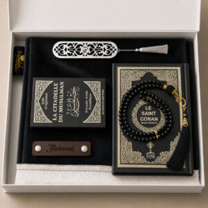Le coffret tapis de prière personnalisé noir Carbone Sajadah avec son tapis à franges blanches, sa lanière en cuir véritable couleur chocolat, son tasbih classique, son exemplaire de "la citadelle du musulman" et son exemplaire du "Saint Coran".