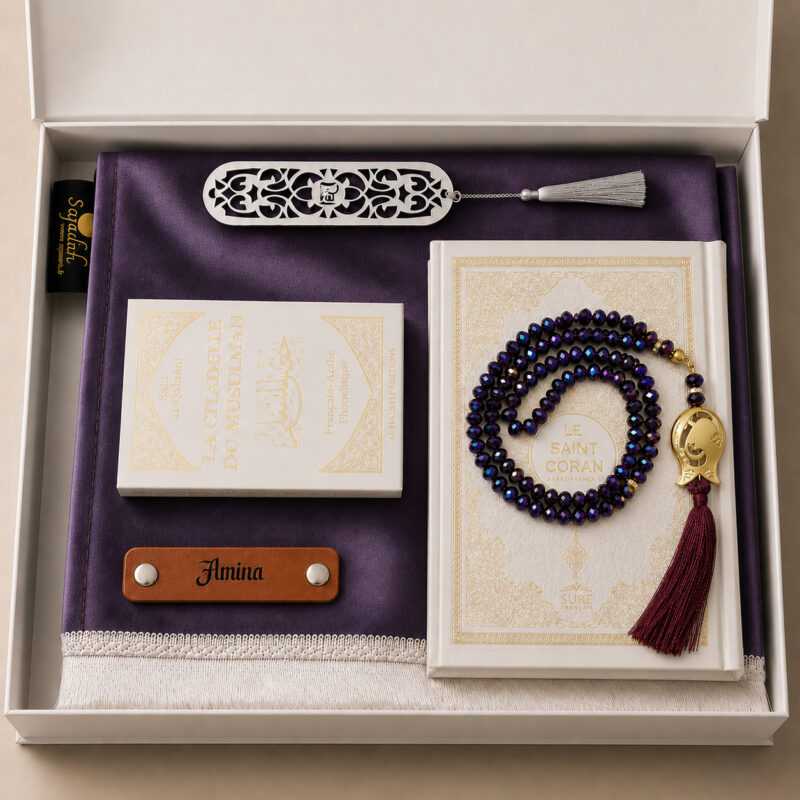 Das personalisierte Sajadah Gebetsteppich-Geschenkset in Manganviolett mit einem Teppich mit weißen Fransen, einem Riemen aus echtem braunem Leder, einem Tasbih in Kristalloptik, einem Exemplar von „Die Festung des Muslims“ und einem Koran.