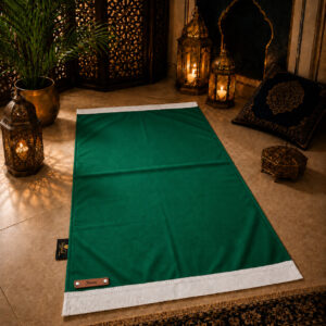 Le tapis de prière personnalisé vert Impérial Sajadah avec ses franges blanches et sa lanière en cuir véritable marron.