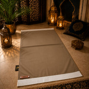 Le tapis de prière personnalisé beige Châtain Sajadah avec ses franges blanches et sa lanière en cuir véritable couleur marron.