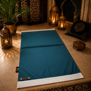 Le tapis de prière personnalisé bleu Azur Sajadah avec ses franges blanches et sa lanière en cuir véritable chocolat.