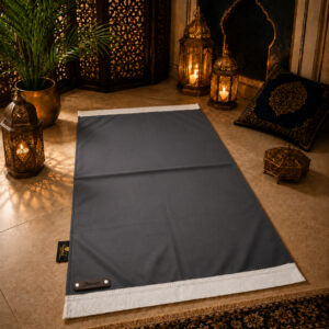Le tapis de prière personnalisé gris Ardoise Sajadah avec ses franges blanches et sa lanière en cuir véritable chocolat.