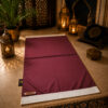 Le tapis de prière personnalisé rose Framboise Sajadah avec ses franges blanches et sa lanière en cuir véritable couleur marron.