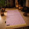 Le tapis de prière personnalisé rose Poudre Sajadah avec ses franges dorées et sa lanière en cuir véritable couleur chocolat.