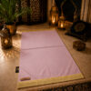 Le tapis de prière personnalisé rose Poudre Sajadah avec ses franges dorées et sa lanière en cuir véritable couleur marron.