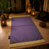 Der personalisierte Sajadah Gebetsteppich in Manganviolett mit goldenen Fransen und einem Riemen aus echtem schokoladenbraunem Leder.