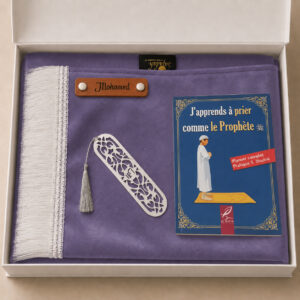Le coffret tapis de prière enfant violet Sajadah pour garcon avec ses franges blanches et sa personnalisation en cuir véritable de couleur marron.