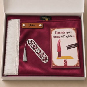 Le coffret tapis de prière enfant rose Framboise Sajadah pour fille avec ses franges blanches et sa personnalisation en cuir véritable de couleur marron.