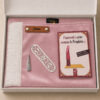 Le coffret tapis de prière enfant rose Poudre Sajadah pour fille avec ses franges blanches et sa personnalisation en cuir véritable de couleur marron.