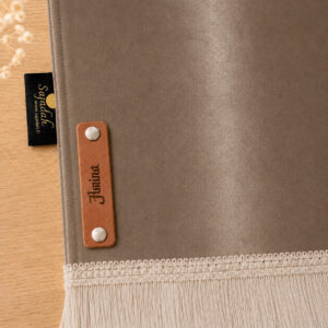Zoom sur la personnalisation en cuir véritable de couleur marron portant votre prénom du tapis de prière Sajadah pour enfant marron Cannelle.