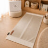 Le tapis de prière Sajadah de couleur beige Crème avec ses franges blanches et sa personnalisation en cuir véritable de couleur marron.