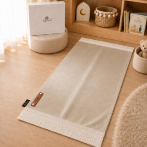 Le tapis de prière Sajadah de couleur beige Crème avec ses franges blanches et sa personnalisation en cuir véritable de couleur marron.
