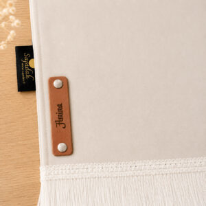 Zoom sur la personnalisation en cuir véritable de couleur marron portant votre prénom du tapis de prière Sajadah pour enfant blanc Ivoire.