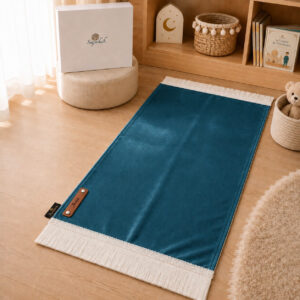 Le tapis de prière Sajadah de couleur bleu Azur Pin avec ses franges blanches et sa personnalisation en cuir véritable de couleur marron.