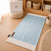 Le tapis de prière Sajadah de couleur bleu Ciel avec ses franges blanches et sa personnalisation en cuir véritable de couleur marron.