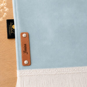 Zoom sur la personnalisation en cuir véritable de couleur marron portant votre prénom du tapis de prière Sajadah pour enfant bleu Ciel.