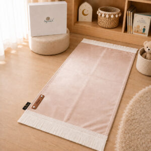 Le tapis de prière Sajadah de couleur rose Pâle avec ses franges blanches et sa personnalisation en cuir véritable de couleur marron.