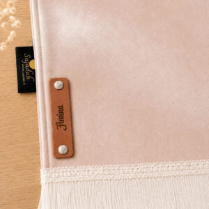 Zoom sur la personnalisation en cuir véritable de couleur marron portant votre prénom du tapis de prière Sajadah pour enfant rose Pâle.
