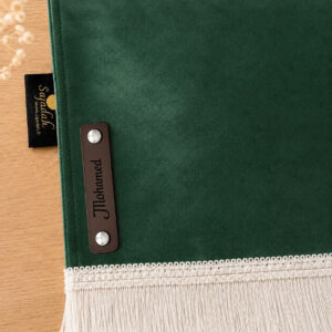 Zoom sur la personnalisation en cuir véritable de couleur chocolat portant votre prénom du tapis de prière Sajadah pour enfant vert Imperial.