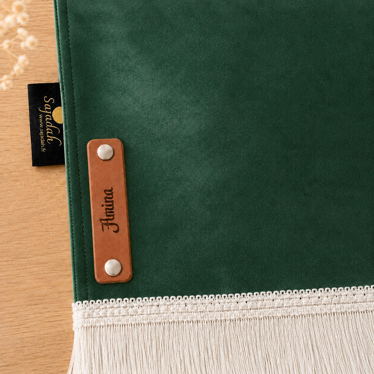 Zoom sur la personnalisation en cuir véritable de couleur marron portant votre prénom du tapis de prière Sajadah pour enfant vert Imperial.