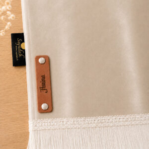 Zoom sur la personnalisation en cuir véritable de couleur marron portant votre prénom du tapis de prière Sajadah pour enfant beige Crème.