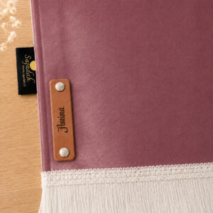 Zoom sur la personnalisation en cuir véritable de couleur marron portant votre prénom du tapis de prière Sajadah pour enfant rose Chair.